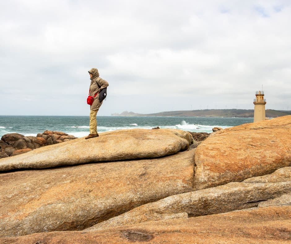 Caminho de Finisterra, homem aprecia a brutalidade do Atlântico em Muxía