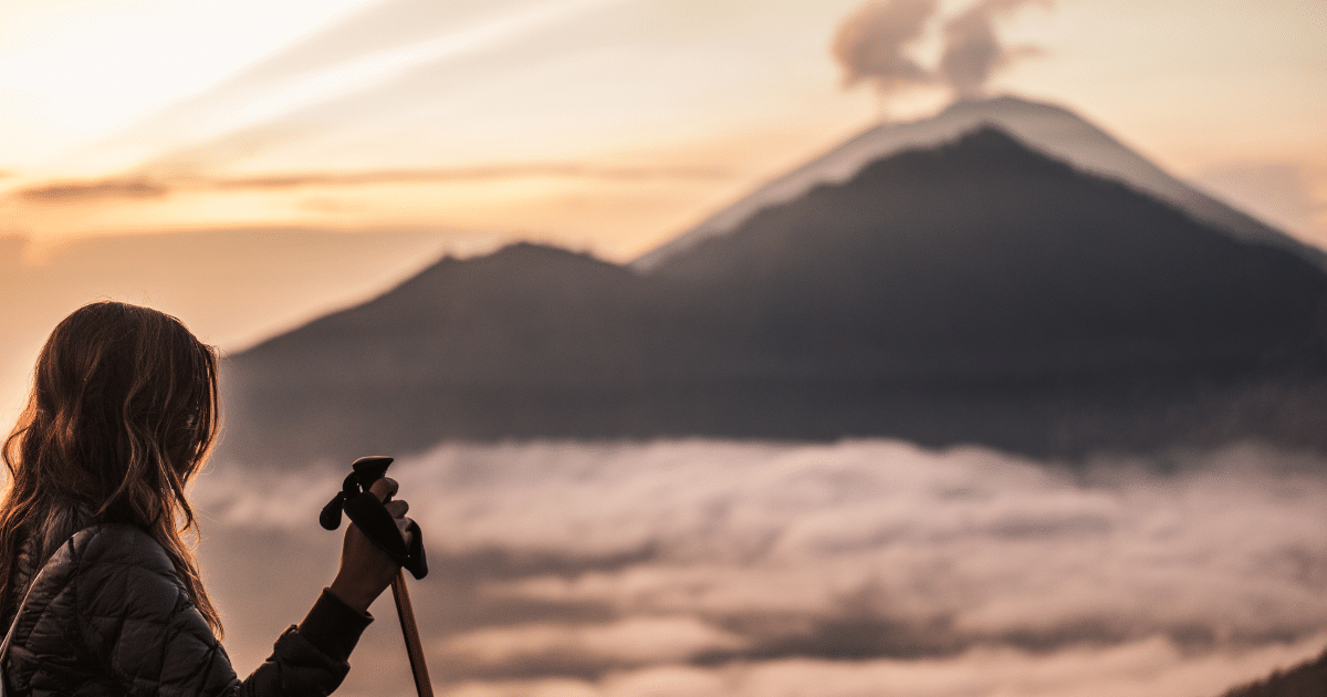 Mulher em viagem em modo selfguided, numa caminhada para observação de vulcões