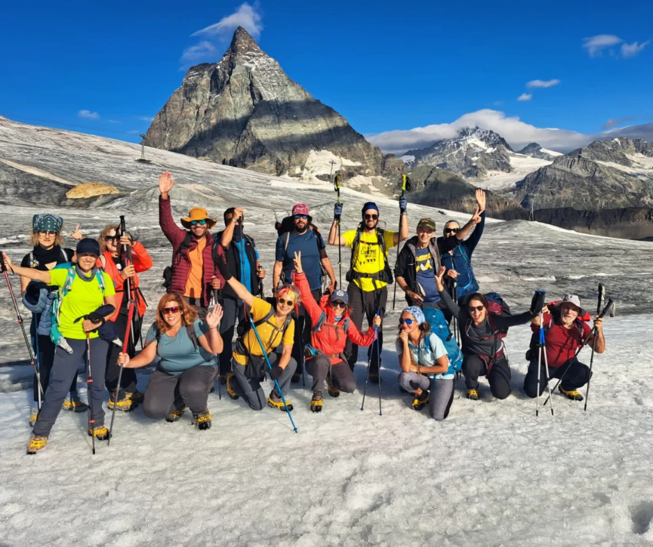 um grupo de pessoas a posar para uma fotografia em frente a uma montanha do monte Cervino rumo a Zermat